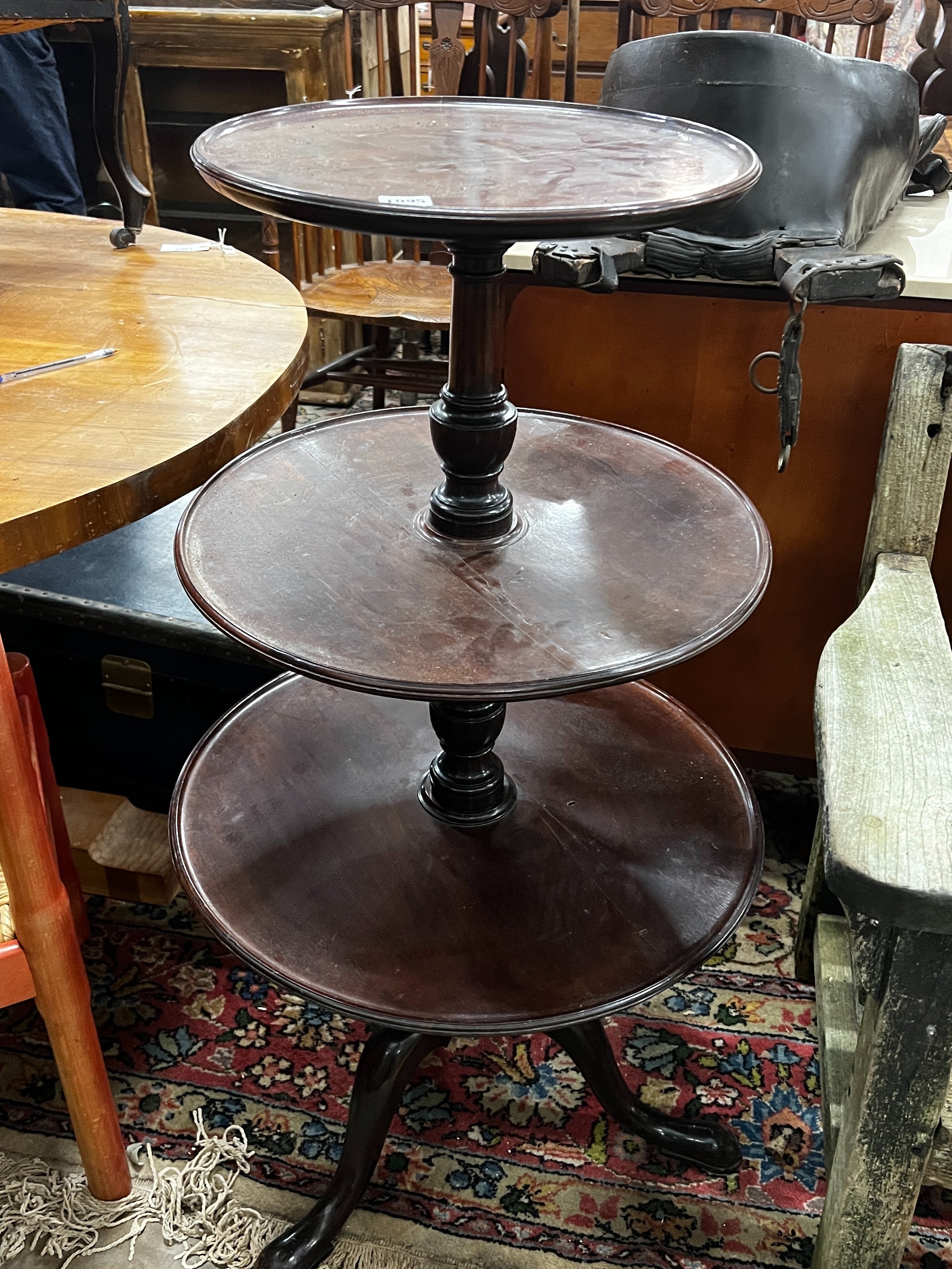 A George III and later circular mahogany three tier dumb waiter, height 108cm